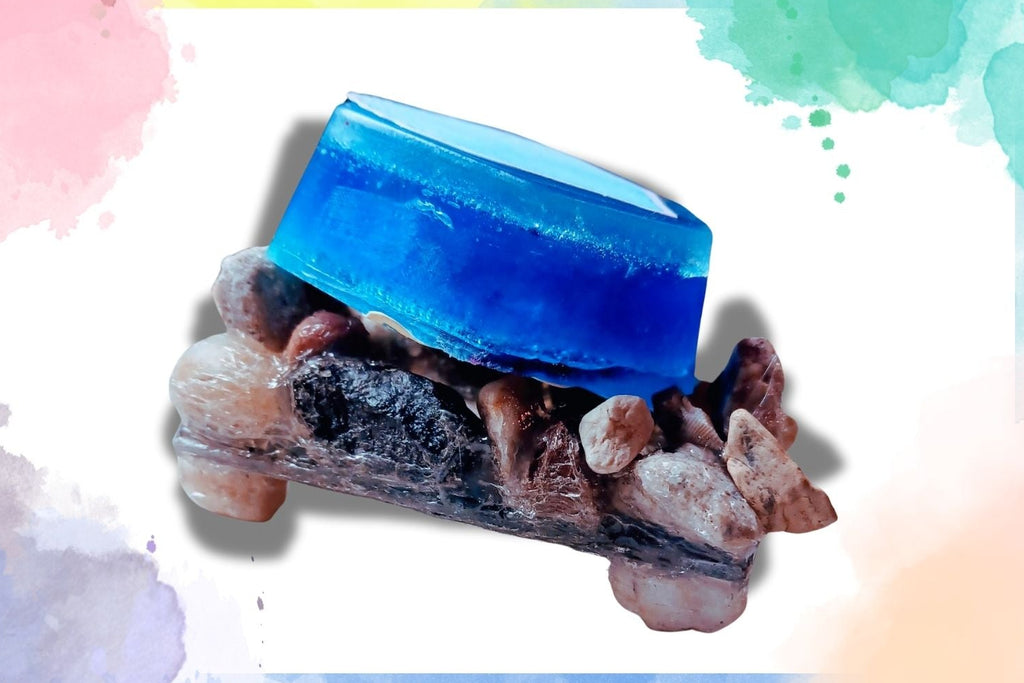 A blue rectangular hand soap placed on a dish made of stones.